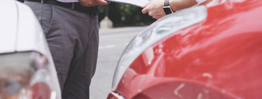 Two individuals discussing paperwork after a car accident